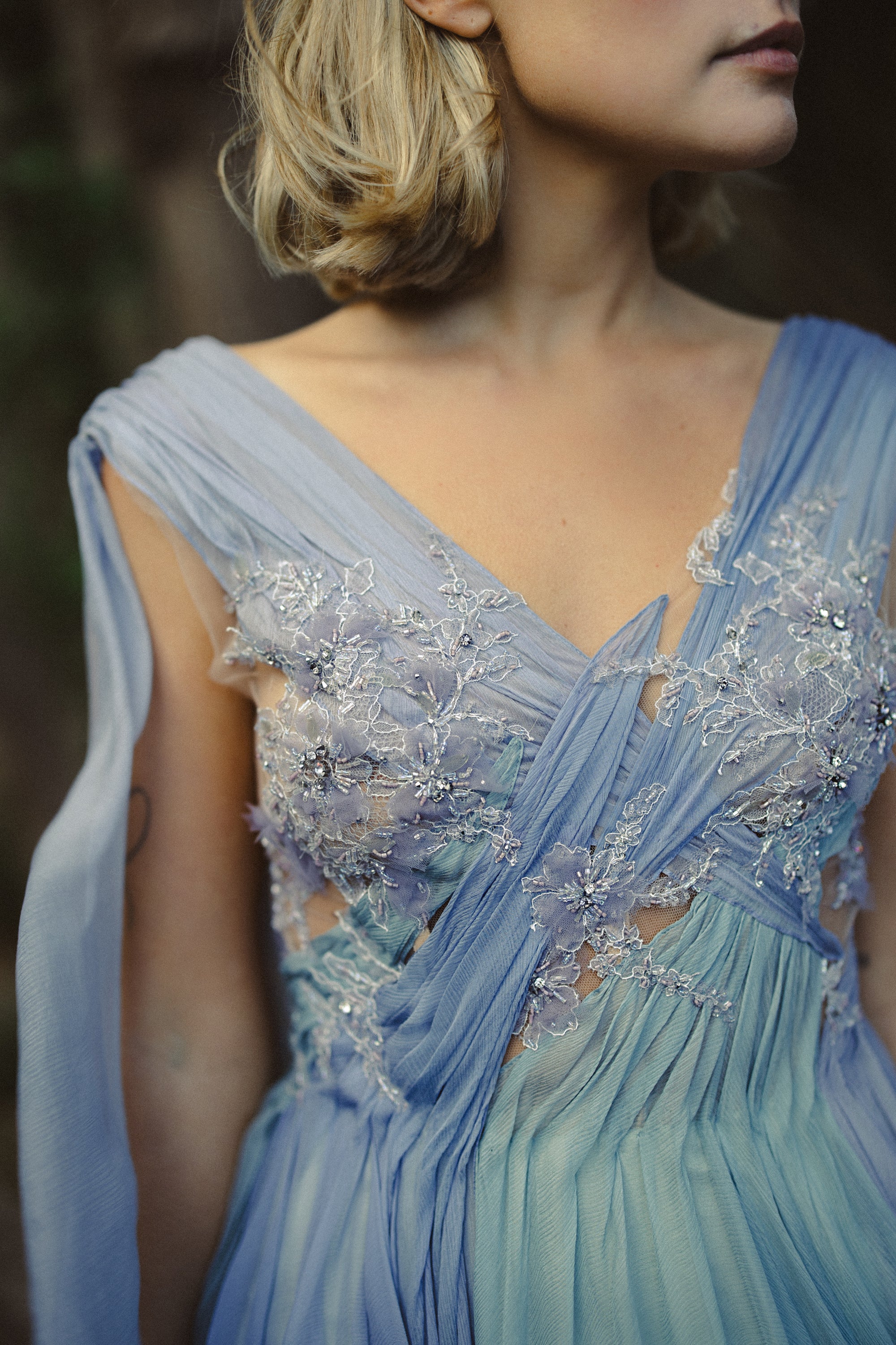 Aéliea ethereal wedding dress close-up — cold-grey beaded lace bodice with sheer mesh insert and multicolored pleating detail — MYWONY Bridal