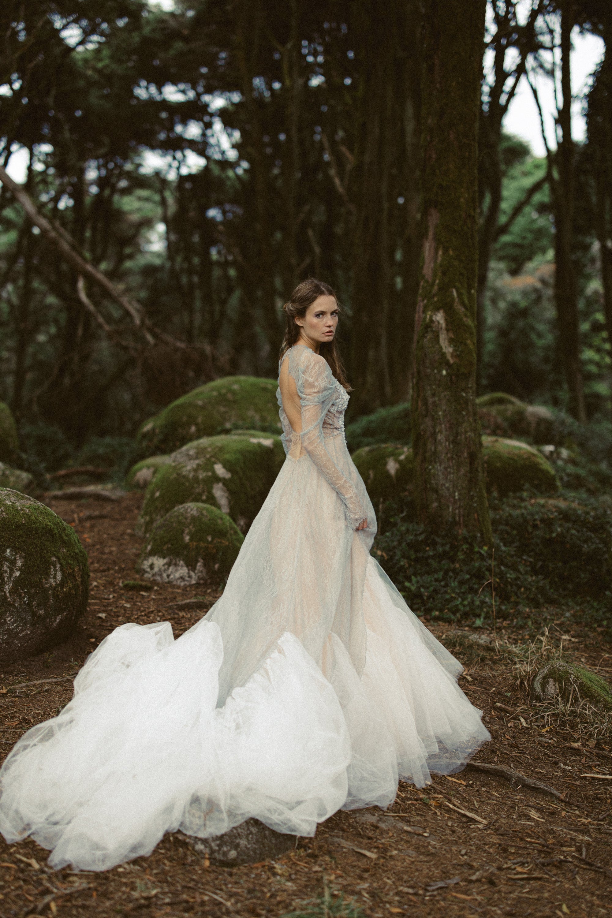 Elystra whimsical wedding dress with flowing tulle skirt, dove-grey floral lace bodice, and draped sleeves in enchanted forest — MYWONY Bridal