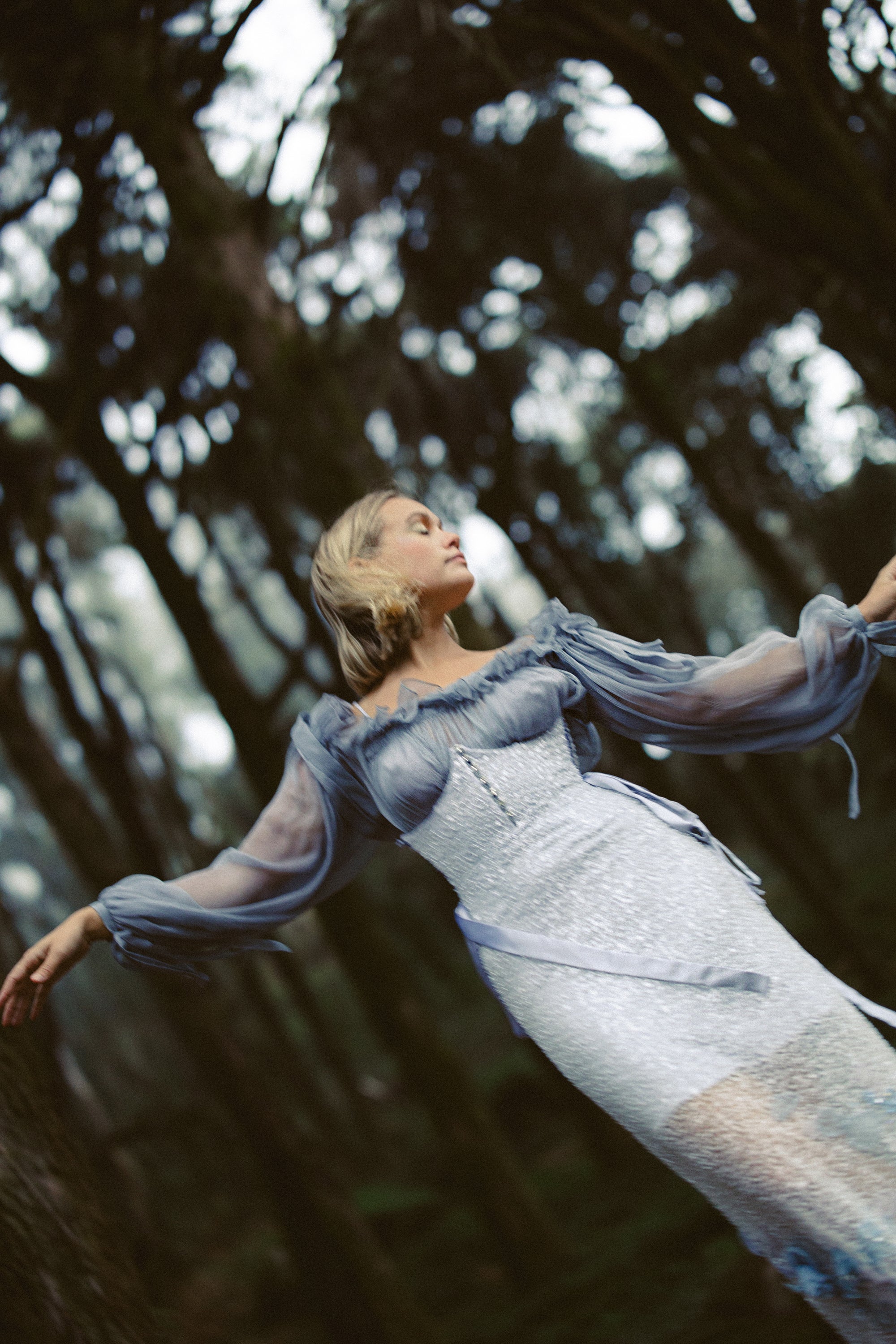 Laetisse ethereal wedding dress — flowing storm-grey silk chiffon gown with off-shoulder sleeves, enchanted forest bridal photoshoot by MYWONY