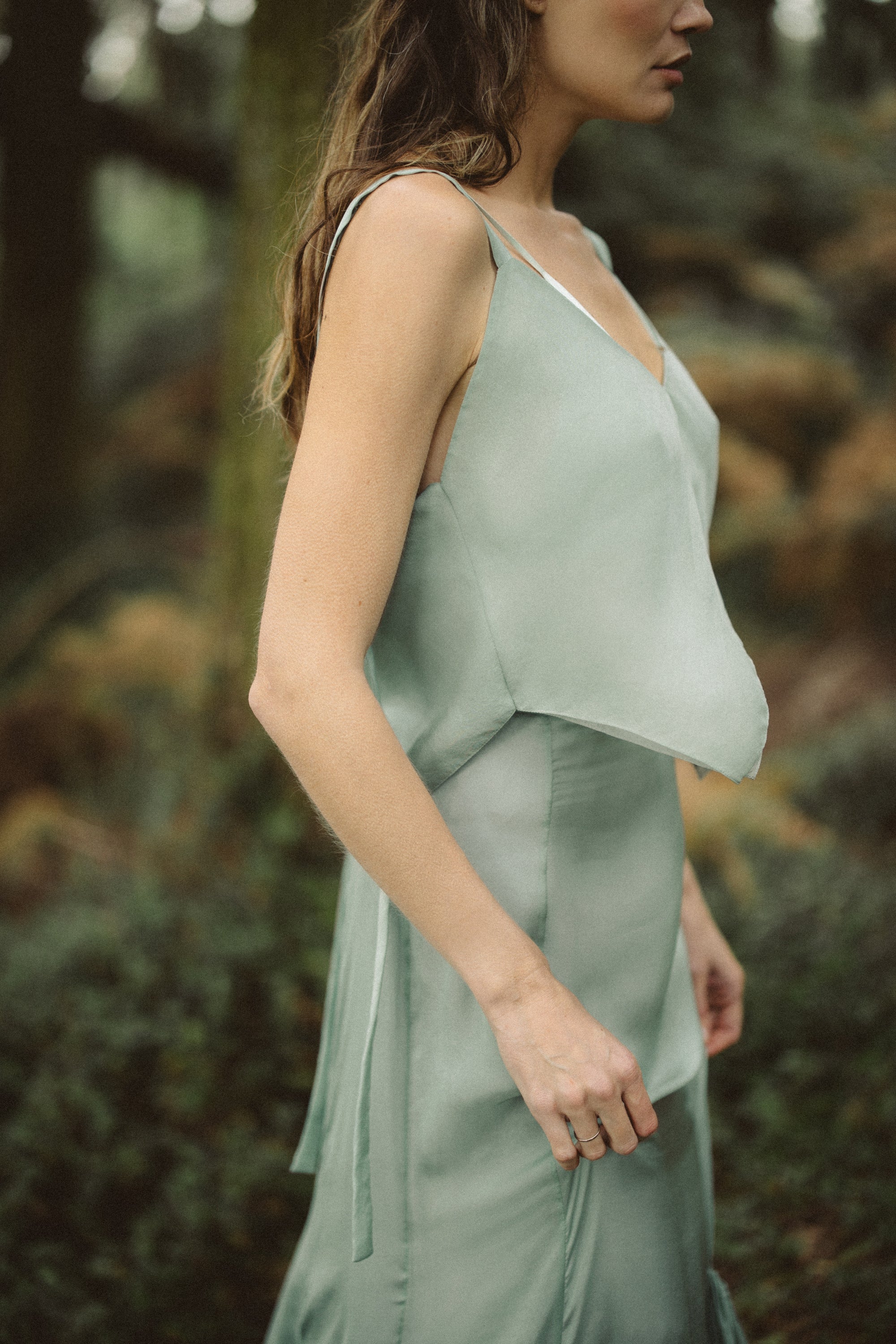 Side profile of Miryelle Silk Top bridal chiffon separate by MYWONY, pale moss green with slender straps, ethereal wedding top in forest