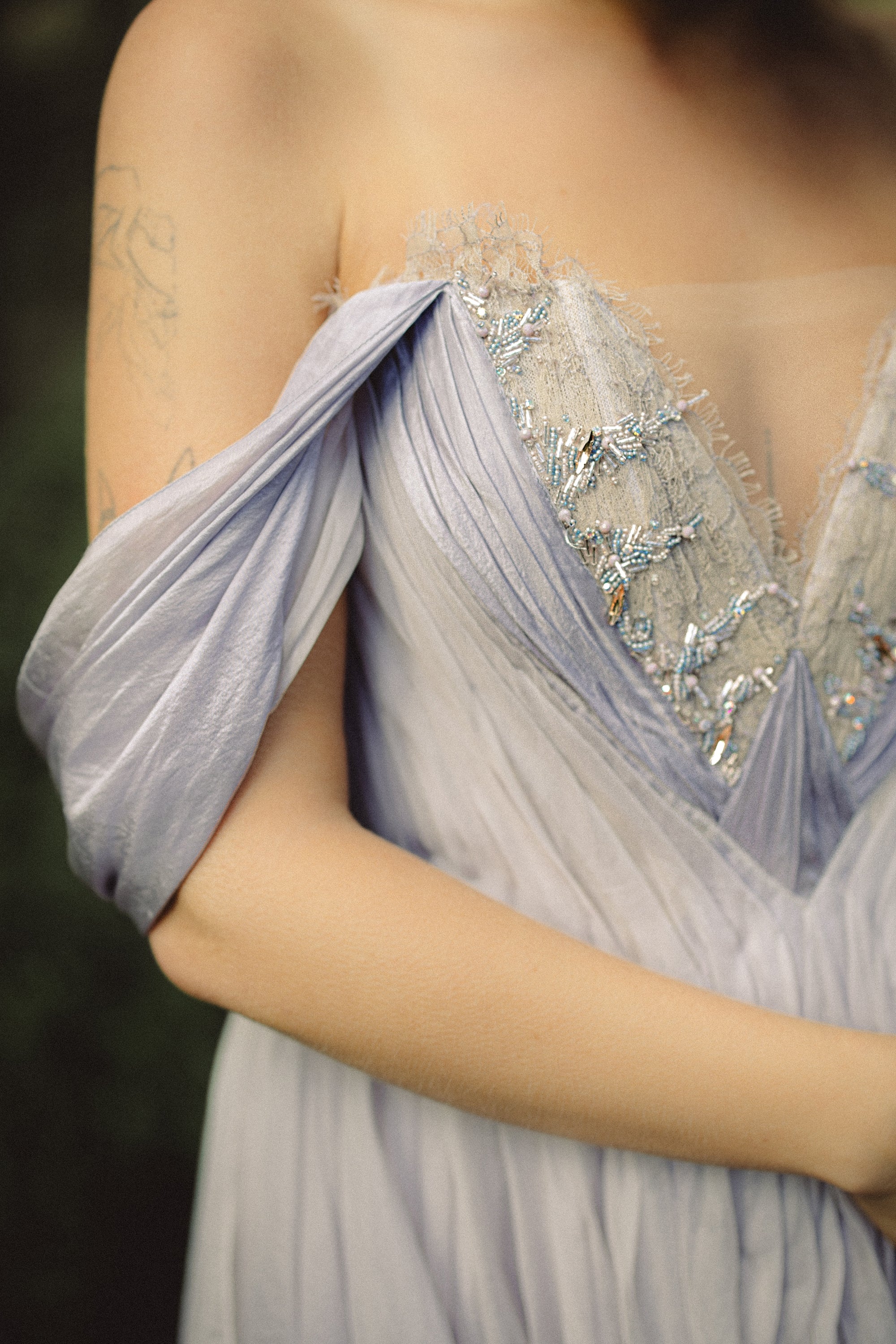 Close-up of Silynne custom wedding gown beaded lace-pleated corset with sheer mesh insert and off-shoulder neckline — MYWONY Bridal