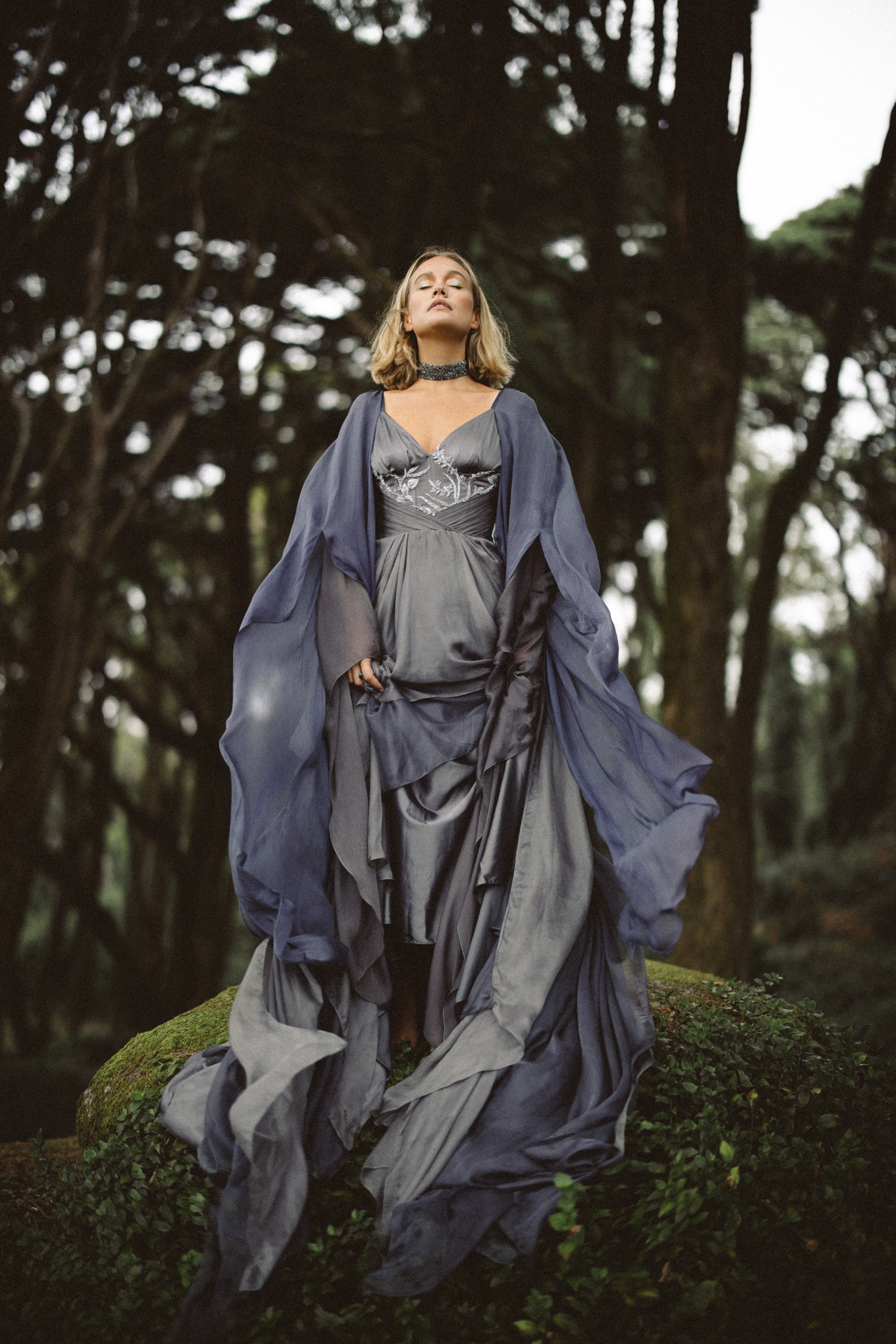 Vea chiffon wedding dress — full-length view with flowing train and two-layered sleeves, forest bridal portrait by MYWONY