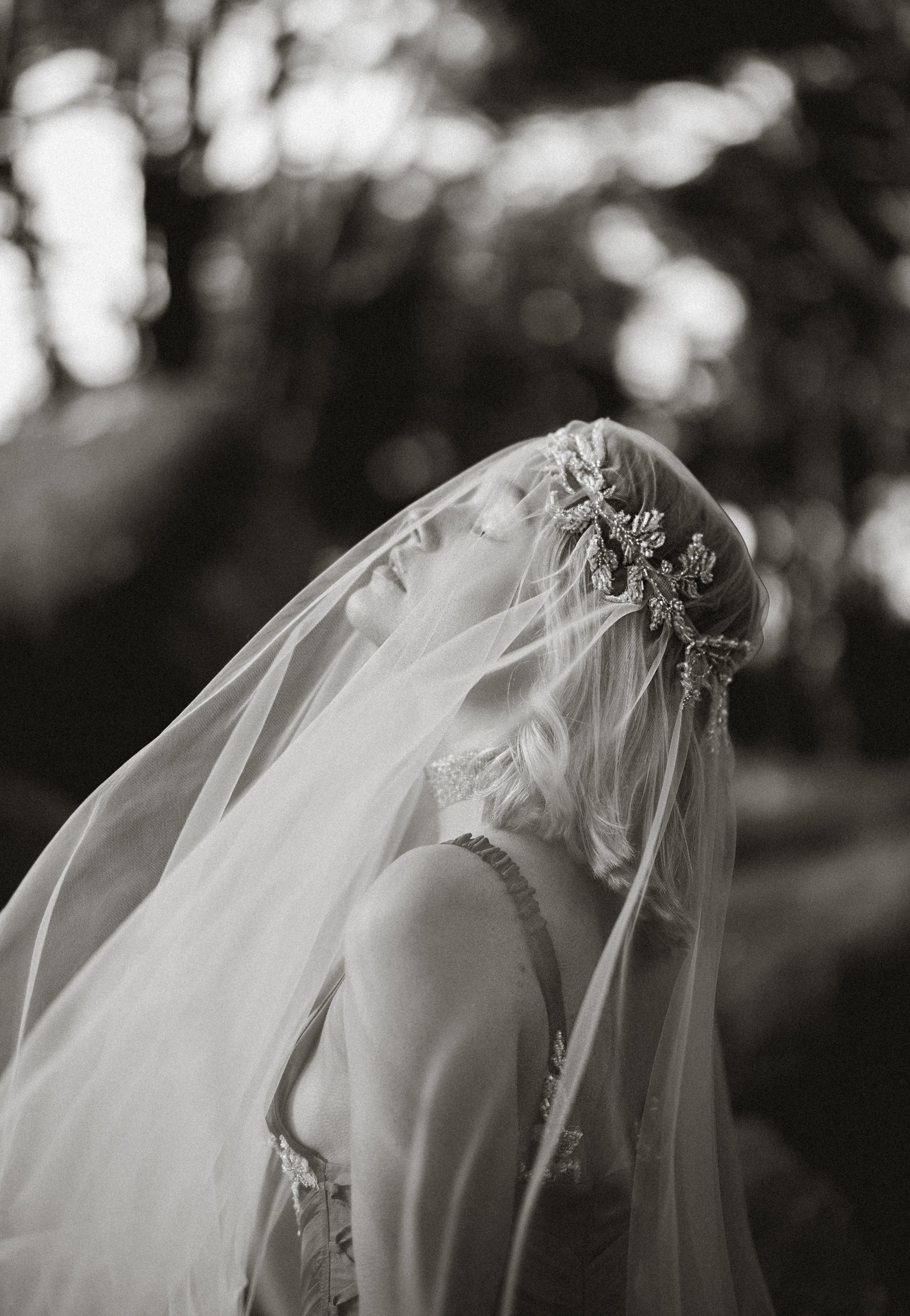 Back view of Vea Veil custom wedding veil by MYWONY showing flowing floor-length tulle drape with beaded lace headpiece in romantic black and white