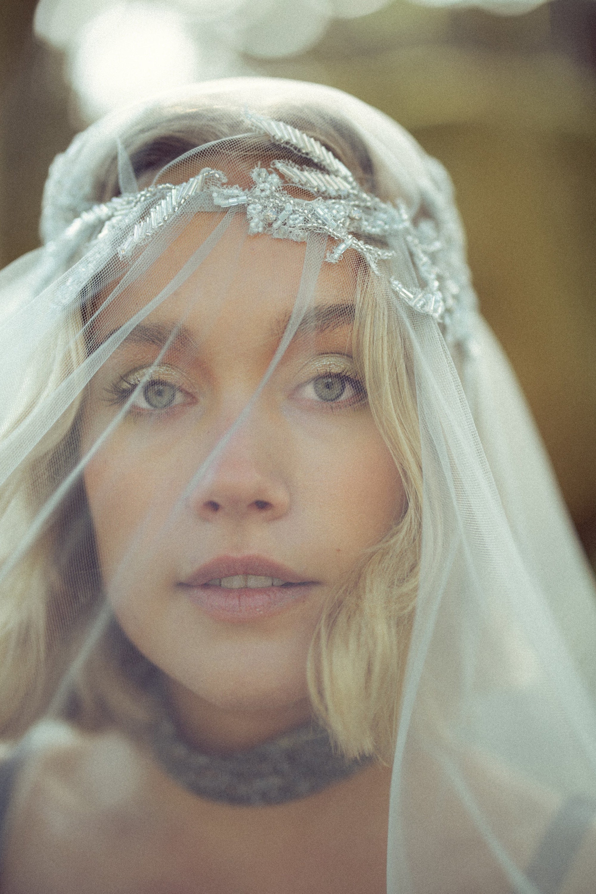 Bride wearing Vea Veil ethereal blue tulle bridal veil by MYWONY with beaded lace crown headpiece detailing for whimsical forest wedding