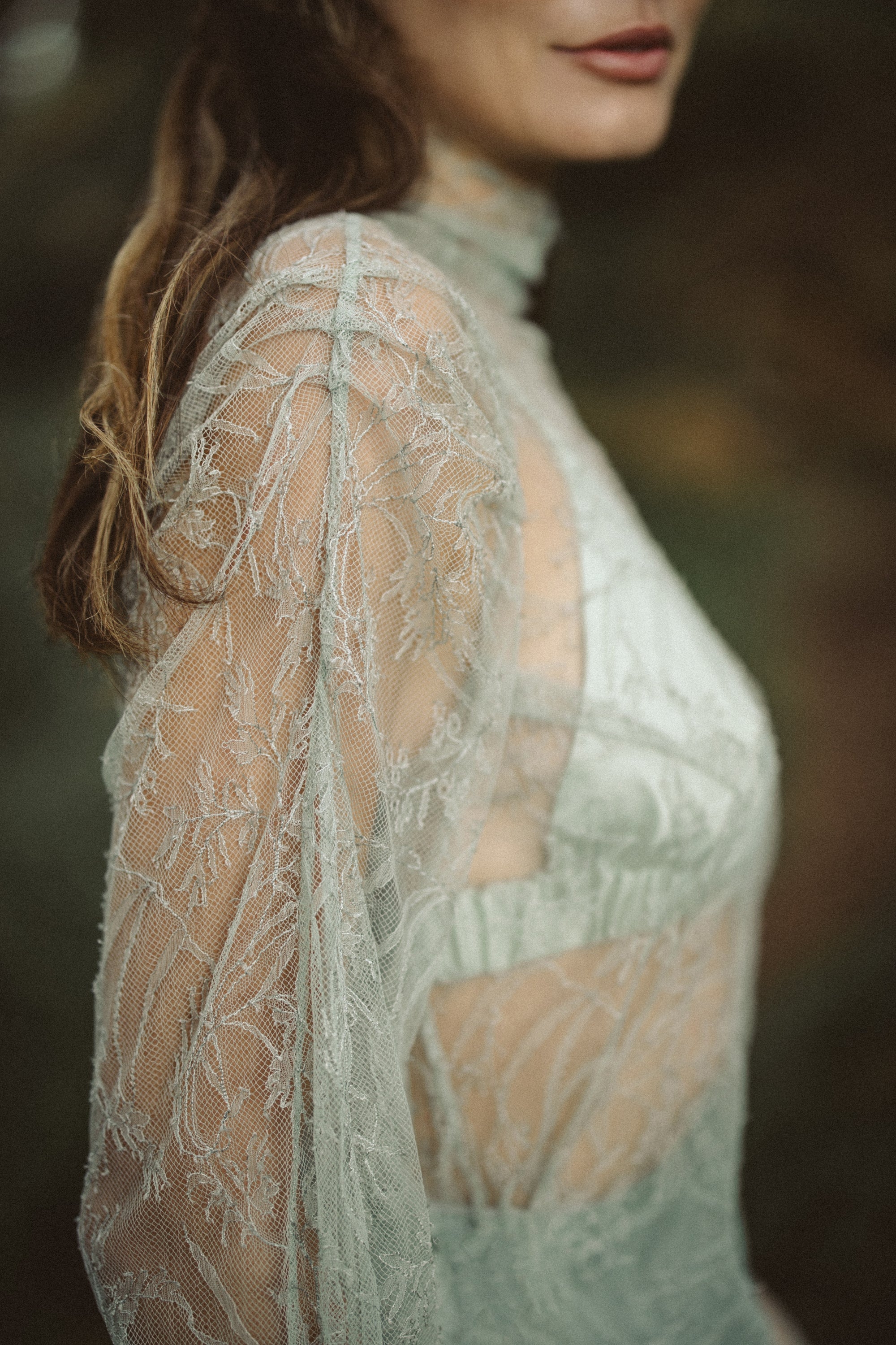 An intimate side profile highlights the sheer texture of the Miryelle lace top, featuring a high neckline and delicate floral motifs. Layered beneath, a matching pale-green silk triangle bra is visible, showcasing the ensemble's modular, romantic layering options.